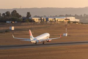 A FlySafair B737-800 departing Lanseria International Airport into the sunset.