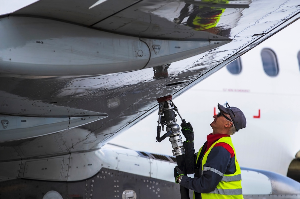 An employee of a ground service company refuels an aircraft. [Credit: Shutterstock/Karolis Kavolelis]